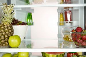 A fridge full of fruits and veggies that has been arranged using fridge organization tips